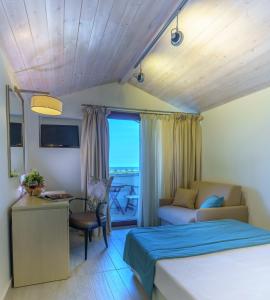 - une chambre avec un lit, un bureau et un canapé dans l'établissement Cosmopolitan Hotel & Spa, à Paralia Katerinis