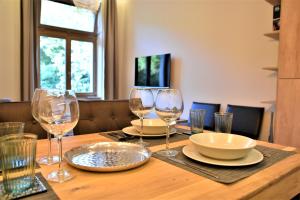 uma mesa de madeira com copos de vinho e pratos em Luxury Flat Near Castle Hill em Budapeste