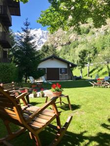 un grupo de sillas de madera sentadas en un patio en Hotel Dei Camosci, en Courmayeur