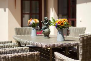 a table with three vases with flowers on it at Leo Vendeghaz in Eger