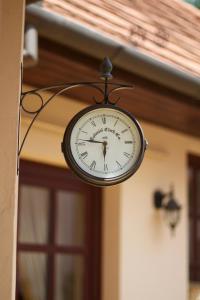 a clock hanging from the side of a building at Leo Vendeghaz in Eger