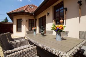 a wooden table with chairs and a vase of flowers on it at Leo Vendeghaz in Eger