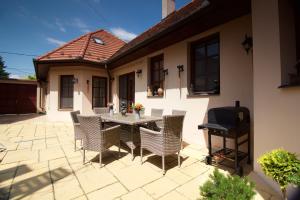 a patio with a table and chairs and a grill at Leo Vendeghaz in Eger