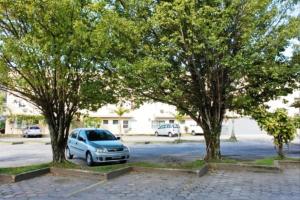 a car parked between two trees in a parking lot at Hotel Atlantico Sul in Caraguatatuba