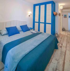 een blauw bed met blauwe kussens in een slaapkamer bij Faro di Capo Testa in Bonifacio