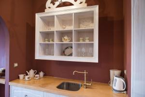 a kitchen with a sink and a cabinet with dishes at Cretan Renaissance in Chania Town