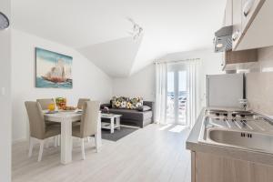 uma cozinha e sala de estar com uma mesa e um sofá em Apartments HIPERION em Zadar