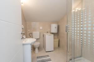 uma casa de banho com um WC, um lavatório e um chuveiro em Apartments HIPERION em Zadar