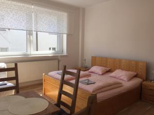 1 Schlafzimmer mit 2 Betten mit rosa Kissen und einem Fenster in der Unterkunft Willa Przy Plaży Gdynia Kamienna Góra in Gdynia