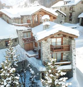 een huis in de sneeuw met besneeuwde daken bij Chalet Barmaz in Val dʼIsère