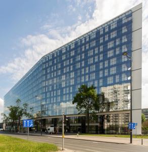 un grand bâtiment en verre avec une rue en face dans l'établissement Apartamenty Vola Residence, à Varsovie