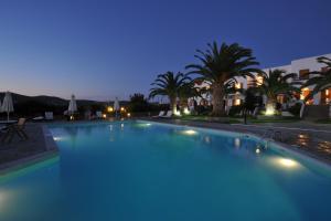 a large swimming pool at night with palm trees at Eri Hotel in Parikia