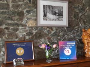 a table with a picture and a vase of flowers at Agroturystyka Łysa Góra in Jelenia Góra