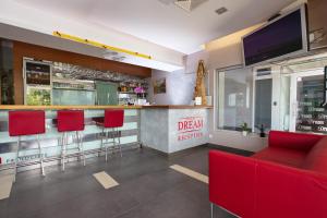 um bar com bancos de bar vermelhos e uma televisão em Dream Hotel em Velika Gorica