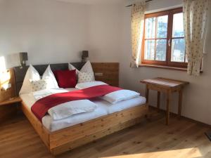 una camera con letto in legno e cuscini rossi e bianchi di Family Retreat Maria Alm a Maria Alm am Steinernen Meer