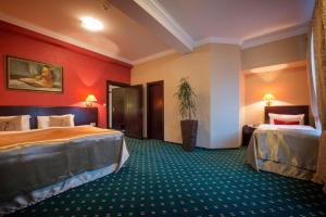 um quarto de hotel com duas camas e paredes vermelhas em Hotel Europa em Poprad