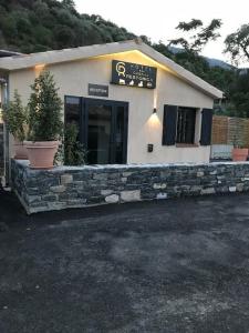 un bâtiment avec un mur en pierre devant lui dans l'établissement Casa di a Restonica, à Corte