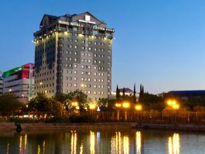 un grand bâtiment avec des lumières devant une masse d'eau dans l'établissement Hotel Sevilla Center, à Séville