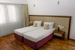 een hotelkamer met een groot bed met witte lakens bij City5 ROOMS & SUITES by LSA in Skopje