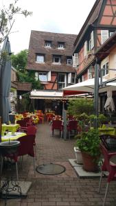 eine Außenterrasse mit Tischen und Stühlen sowie ein Gebäude in der Unterkunft Chambres touristiques La Cour Des Hôtes in Obernai