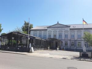 un edificio blanco con gente caminando delante de él en Hotel Restaurant Hellas, en Gelting