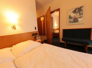 a hotel room with a bed and a television at Karaman Group Hotel in Bad Nenndorf