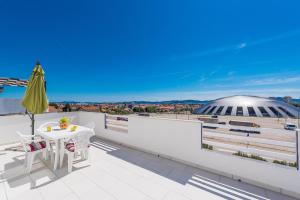 uma varanda com uma mesa e vista para um estádio em Apartments HIPERION em Zadar