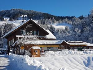 un edificio coperto di neve di fronte a una montagna di Rest. Beaver Creek Ranch a Rothenthurm