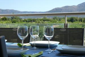 a table with three wine glasses on a table with a view at Appartement plage Salata Rosas in Roses