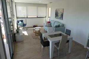 a living room with a table and a couch at Appartement plage Salata Rosas in Roses