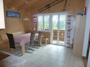 jadalnia ze stołem, krzesłami i oknami w obiekcie Chalet Verbrunnenhaus Grindelwald w mieście Grindelwald