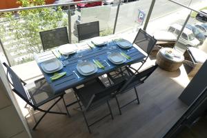 a table and chairs with plates and dishes on a balcony at Appartement plage Salata Rosas in Roses