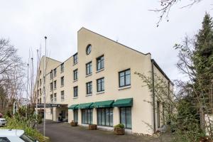 um grande edifício branco com toldos verdes em Trip Inn Bristol Hotel Mainz em Mainz