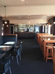 une salle à manger avec des tables et des chaises ainsi qu'un bar dans l'établissement The Kamo Hotel, à Whangarei