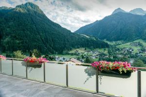 balkon z kwiatami i widokiem na dolinę w obiekcie Appartements Ausblick w mieście St. Gallenkirch