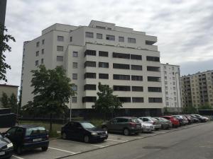 un gran edificio blanco con coches aparcados en un aparcamiento en Korkyra, en Zagreb