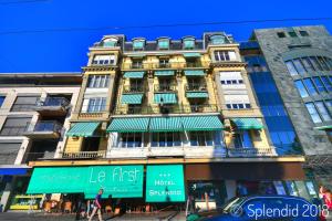 een hoog gebouw met groene luifels erop bij Hotel Splendid in Montreux