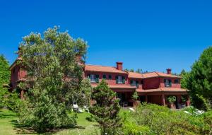 een groot rood huis met bomen ervoor bij Quinta Santo Antonio Da Serra in Santa Cruz