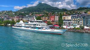 een cruiseschip in het water naast een stad bij Hotel Splendid in Montreux