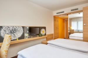 Un pat sau paturi într-o cameră la H+ Hotel Zürich