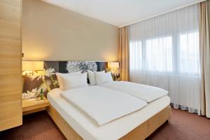 Un pat sau paturi într-o cameră la H+ Hotel Zürich