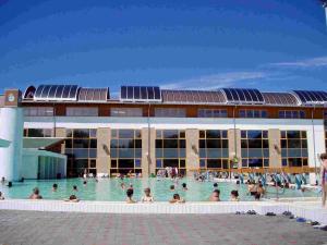 un grupo de personas en la piscina frente a un edificio en Abigél Vendégház, en Harkány