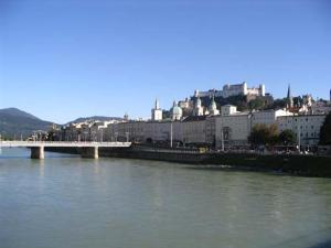 a bridge over a river with a city in the background at Haus Wartenberg in Salzburg