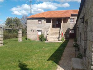 una gran casa de piedra con un patio de césped en Quinta da Fonte Arcada, en Paço de Sousa