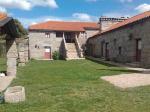 un antiguo edificio de piedra con un patio de césped en Quinta da Fonte Arcada, en Paço de Sousa