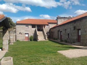 un edificio con un patio de césped delante de él en Quinta da Fonte Arcada, en Paço de Sousa