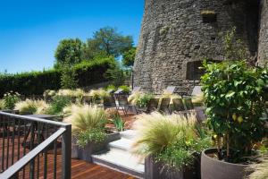 eine Terrasse mit Stühlen und Pflanzen vor einem Steingebäude in der Unterkunft Relais San Vigilio al Castello in Bergamo