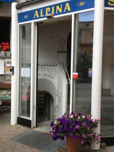 a store entrance with a flower pot in front of it at Hotel Alpina in Zernez