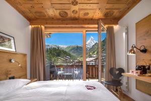 a bedroom with a view of a mountain at Swiss Alpine Hotel Allalin in Zermatt