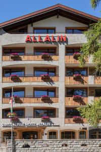 an apartment building with a hotel sign on it at Swiss Alpine Hotel Allalin in Zermatt